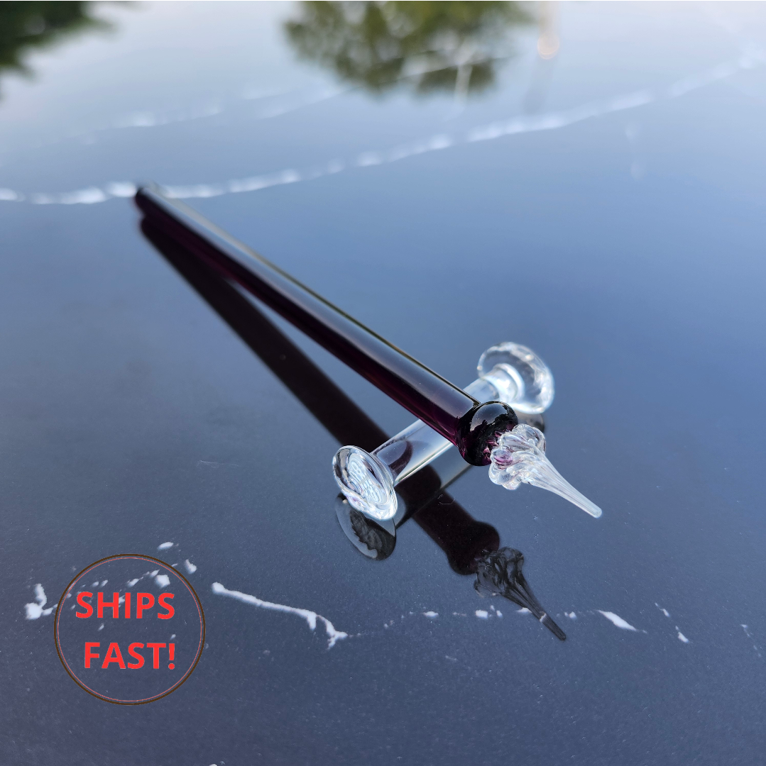 Claret red glass dip pen resting in wooden gift box with spiral tail and transparent body