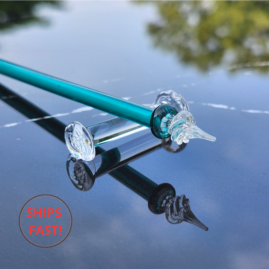 Glass pen dipped in ink—teal grooves reflect ambient light beautifully.